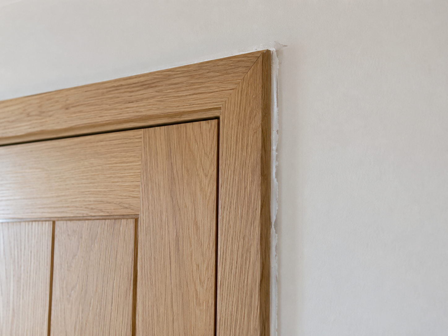 Illustrative example of an unfinished seal around an oak door frame
